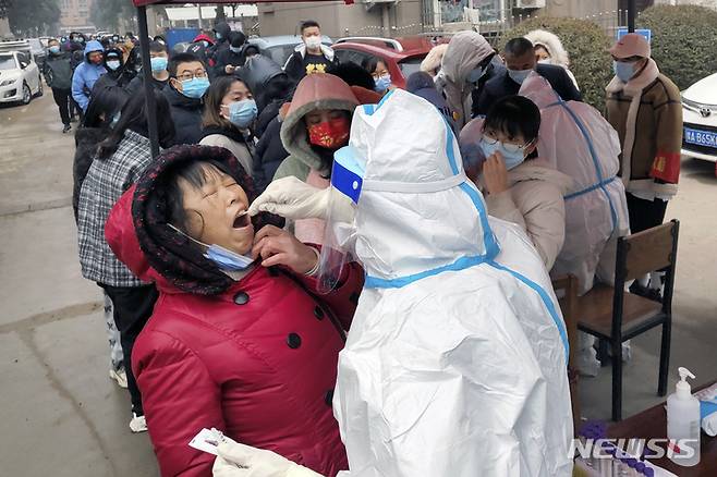 [안양=AP/뉴시스] 10일(현지시간) 중국 허난성 안양시의 화현에서 한 의료인이 주민들을 대상으로 코로나19 검사를 하고 있다. 2022.01.11