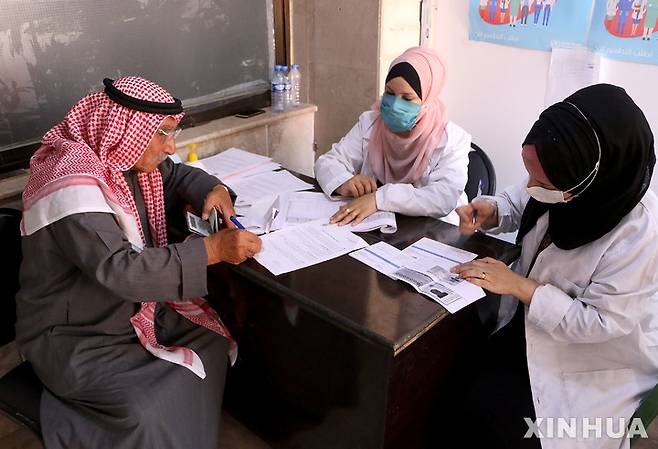 [ 하사카( 시리아)= 신화/뉴시스] 시리아 북동부의 하사카주에서 지난 해 7월 의료진들이 주민에게서 백신접종 신청을 받고 있다.