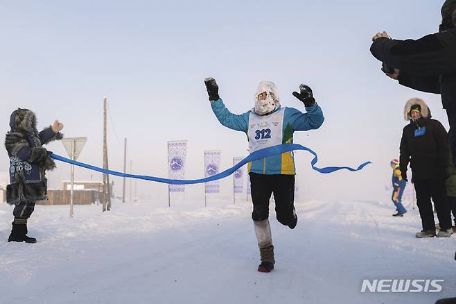 [오이먀콘=AP/뉴시스] 22일(현지시간) 러시아 극동 야쿠티아라고도 알려진 사하공화국의 오이먀콘 인근에서 영하 53도 속 세계에서 가장 추운 국제 마라톤이 열려 한 참가자가 결승 지점에 골인하고 있다. 이 대회엔 아랍에미리트, 미국, 벨라루스 등 65명의 남녀 주자가 참가해 풀코스와 하프 코스를 달렸다. 이 마을은 인간이 거주하는 곳 중 가장 추운 곳이며 얼지 않는 물인 자연 온천이 있다. 2022.01.25.