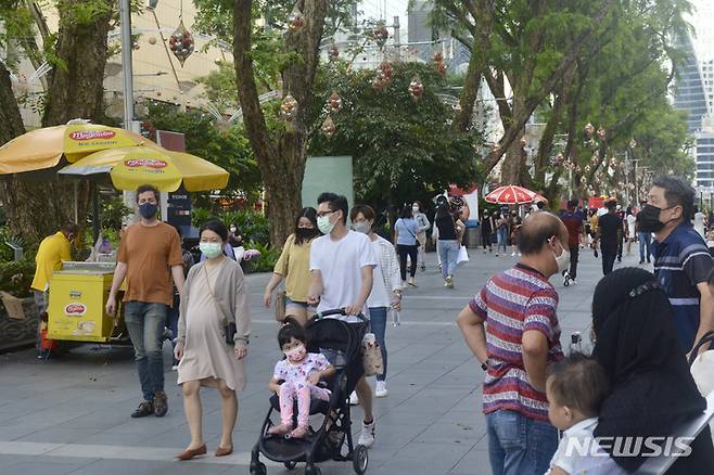 [싱가포르=AP/뉴시스] 11월28일(현지시간) 마스크를 쓴 사람들이 싱가포르 오차드 로드 쇼핑 거리를 걷고 있다. 지난 8월부터 ‘위드 코로나(단계적 일상회복)’ 정책을 시행했던 싱가포르 정부가 코로나19 '오미크론' 변이의 확산을 우려하면서 외국인 입국 절차를 강화하기로 했다. 최근 싱가포르의 코로나19 감염이 늘자 시민들은 '위드 코로나' 시행의 시기가 적절한지 의문을 품기 시작한 것으로 알려졌다. 2021.12.01.