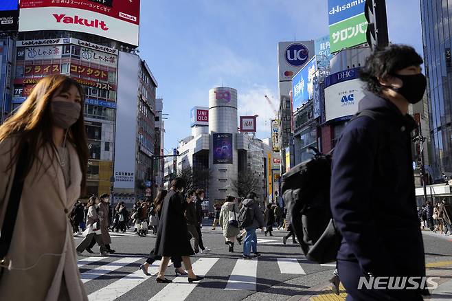 [도쿄(일본)=AP/뉴시스]지난 21일 일본 도쿄에서 코로나19 감염 예방을 위해 마스크를 착용한 시민들이 횡단보도를 건너고 있다. 2022.01.26.