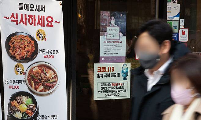 서울 명동의 한 식당 입구에 '코로나19 극복' 안내문이 붙어있다. 뉴스1