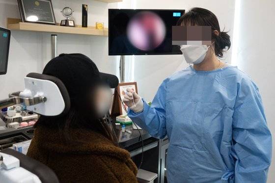 동네 병의원에서 신종 코로나바이러스 감염증(코로나19) 신속항원검사가 시작된 후 첫 주말인 6일 서울 종로구 호흡기전담클리닉인 한 이비인후과에서 의료진이 검체채취를 하고 있다. 뉴스1 (사진은 기사 내용과 무관한 자료사진입니다)