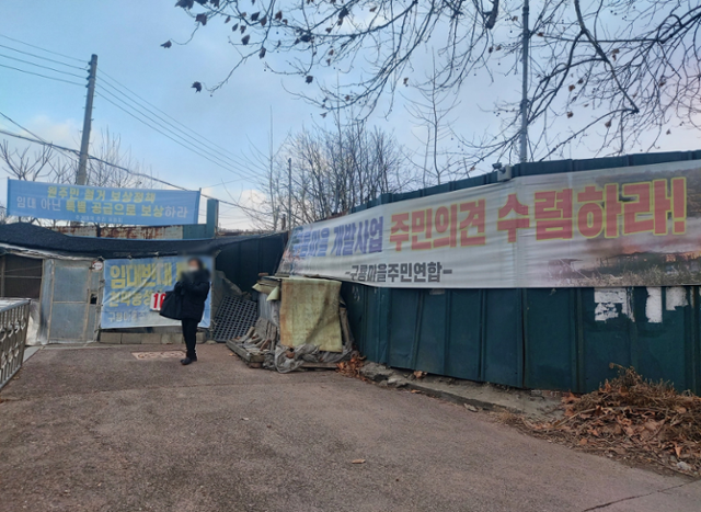 구룡마을 입구에 '주민 의견 수렴하라'고 적힌 빛바랜 현수막이 걸려 있다. 서현정 기자