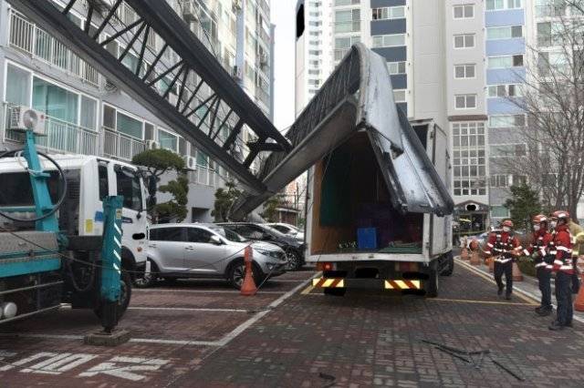 21일 오후 서울 노원구 상계동의 한 아파트에 이삿짐 운반용 사다리차(왼쪽)의 사다리가 뒤틀린 채 쓰러져 있다. 목격자 등에 따르면 이날 이삿짐 운반을 마치고 내려지던 사다리가 옆으로 쓰러지면서 주변에 있던 A 씨(70)와 손자 B 군(6)을 덮쳤다. 이날 사고로 A 씨는 숨졌고, B 군은 병원 치료를 받고 있다. 주차된 차량 5대도 파손됐다. 노원소방서 제공