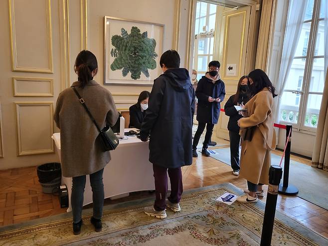 줄을 서서 투표용지를 받는 프랑스 한인들 (파리=연합뉴스) 현혜란 특파원 = 제20대 대통령선거 재외투표 첫날이 23일(현지시간) 오후 프랑스 파리 한국대사관에 마련된 투표소에서 유권자들이 투표용지를 받기 위해 줄을 서서 기다리고 있다. 2022.2.23 runran@yna.co.kr