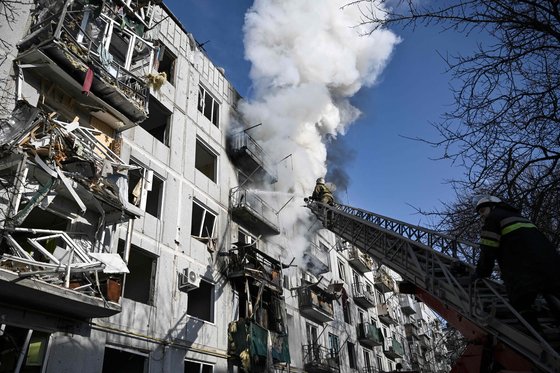 24일(현지시간)러시아 군의 공격으로 우크라이나 동부 추기프의 한 아파트 건물에서 연기가 치솟고 있다,[AFP=연합뉴스]