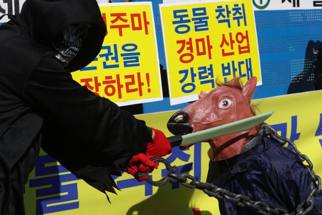 한국동물보호연합 등 동물단체 활동가들이 23일 오후 서울 광화문에서 가진 기자회견에서 퇴역 경주마 생존권 보장 촉구 퍼포먼스를 하고 있다. 뉴스1