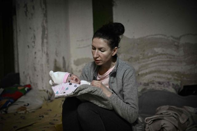 러시아군의 공격을 피해 28일 우크라이나 키예프 방공호로 대피한 한 여성이 아이를 돌보고 있다. 키예프=AFP 연합뉴스
