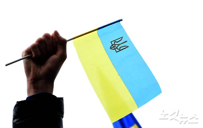 지난 28일 서울 중구 주한 러시아 대사관 앞에서 열린 '러시아의 우크라이나 침공 중단·평화적 해결 촉구 시민사회 공동 기자회견'에 참석한 재한 우크라이나인이 국기를 흔들고 있다. 황진환 기자
