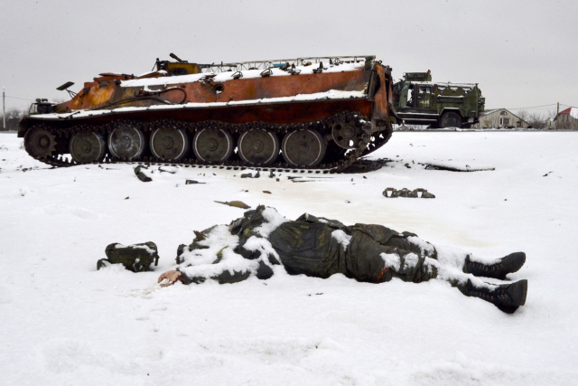 우크라이나 동북부 하리코프 외곽 도로에 파괴된 러시아군 차량들이 멈춰서 있는 가운데 한 러시아 병사의 시신이 널부러져 있다./연합뉴스