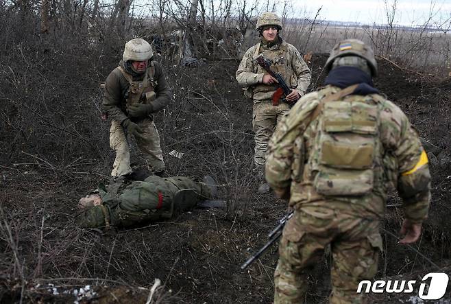 6일 우크라 루간스크 지방에서 러시아 군, 친러시아 반군과 전투를 치른 우크라이나 군이 전사자를 살펴보고 있다. © AFP=뉴스1 © News1 우동명 기자