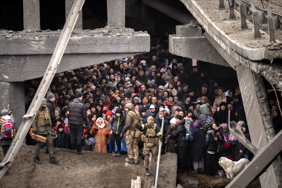 러시아군 폭격에 파괴된 다리 밑에 모여든 우크라 피란민들 - 5일(현지시간) 우크라이나 수도 키이우(키예프) 외곽 이르핀강을 건너 피란하려는 주민들이 러시아군의 폭격으로 파괴된 다리 아래 모여 있다. 2022.3.6 이르핀 AP 연합뉴스