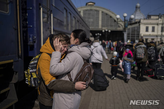 [르비우=AP/뉴시스] 20일(현지시간) 우크라이나 르비우 기차역에서 한 여성이 러시아군에 포위된 마리우폴을 탈출한 아들과 재회하고 있다. 2022.03.21.