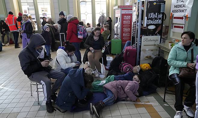 지난 23일(현지시간) 폴란드 남동부 국경도시 프셰미실의 기차역에서 우크라이나 난민들이 바닥에 누워 새우잠을 자고 있다. 프셰미실=AP연합뉴스