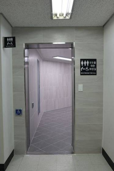 '모두의 화장실' 입구. 장애인이나 어린이가 쉽게 누를 수 있는 곳에 자동문 버튼이 설치돼 있다. 표지판에는 모든 이를 상징하는 5가지 픽토그램이 명시됐다. 김윤교 인턴기자