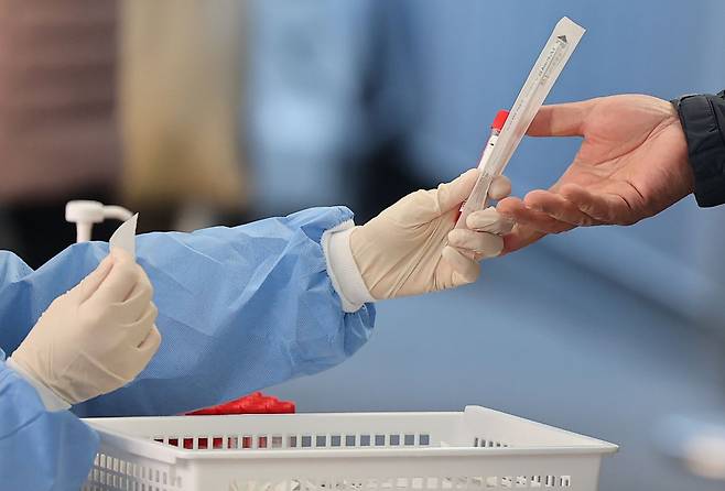 3일 서울 중구 서울역 코로나19 임시선별검사소를 찾은 시민이 PCR 검사 키트를 받고 있다. /연합뉴스