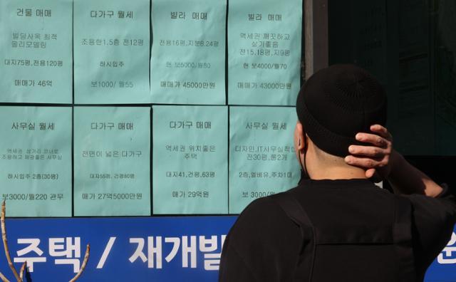 지난달 28일 서울의 한 부동산 중개업소 매물 전단을 한 남성이 바라보고 있다. 연합뉴스