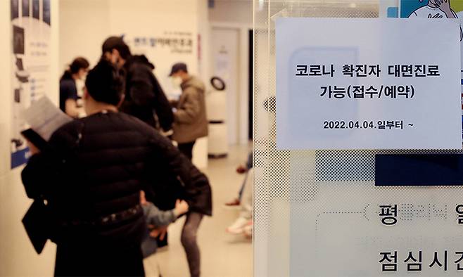 코로나19 확진자에 대한 동네 병원의 대면진료가 시작된 4일 서울 중구 신당 센트럴이비인후과에 '코로나 확진자 대면진료' 접수 관련 안내문이 부착돼 있다. 뉴시스