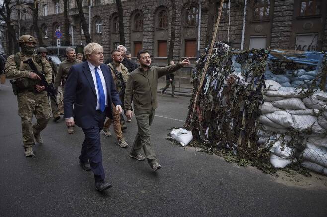 보리스 존슨 영국 총리가 볼로디미르 젤렌스키 우크라이나 대통령과 함께 모래주머니 참호가 설치된 키이우 거리를 돌아보고 있다. AP=연합뉴스