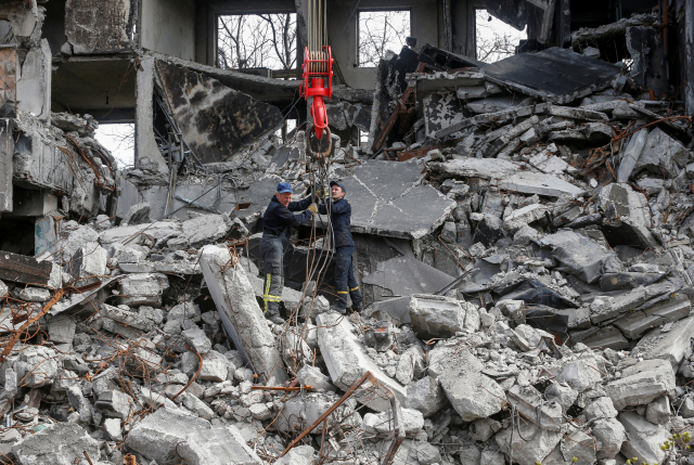 우크라이나 남부 항구도시 마리우폴에서 10일(현지시간) 구조요원들이 러시아군의 폭격을 받아 폐허로 변한 건물 잔해를 헤치고 있다. 연합뉴스