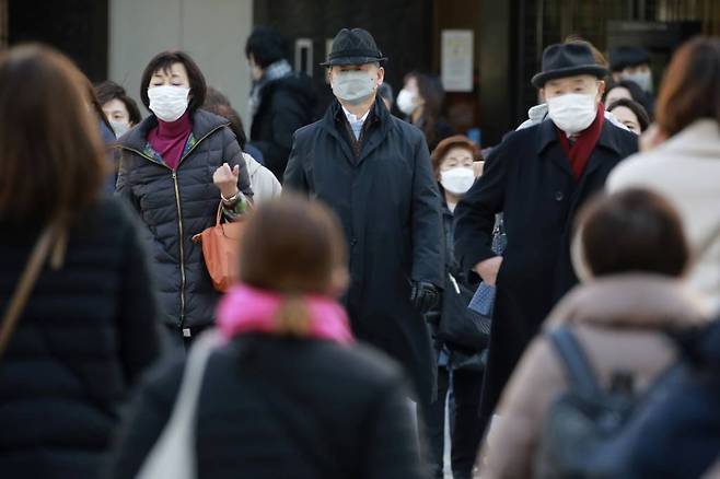 [도쿄=AP/뉴시스] 2월 22일 일본 도쿄에서 코로나19 확산 방지를 위해 마스크를 쓴 시민들이 거리를 걷고 있다.