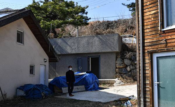 이태구 교수가 지난달 28일 충북 제천 의림지 인근 야산에 본인이 설치한 모형 방공호(가운데) 앞에서 포즈를 취하고 있다. 제천=이한결 기자