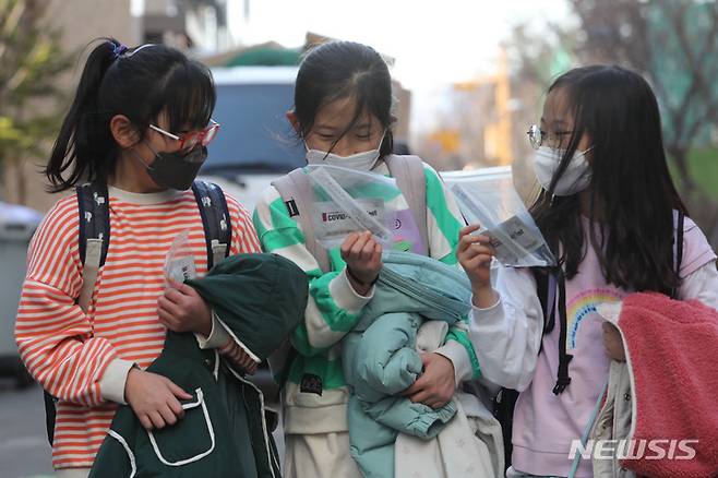 [서울=뉴시스] 지난달 2일 오후 서울 시내 초등학교에서 학생들이 자가진단키트를 살펴보며 하교하고 있다. (사진=뉴시스DB). 2022.04.15. photo@newsis.com
