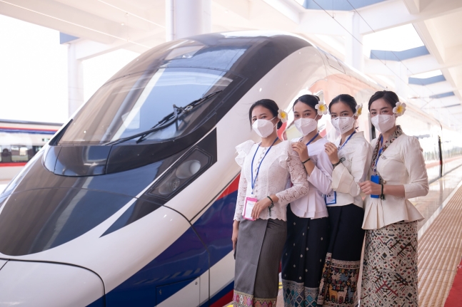 지난해 12월 개통한 중국-라오스간 철도 개통식에서 승무원들이 포즈를 취하고 있다. 중국 윈난성 쿤밍에서 비엔티안까지 1,035㎞를 잇는 이 철도를 위해 라오스 정부는 중국정부로 부터 50억 달러가 넘는 대출을 받았다. 이는 라오스 연간 GDP의 50%가 넘는다.  사진 연합