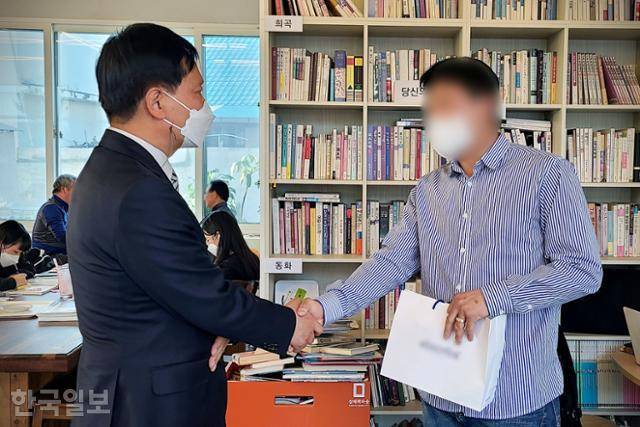 '삼례나라슈퍼 강도치사 사건'에서 범인으로 몰려 억울한 옥살이를 했던 '삼례 3인조' 강인구(오른쪽)씨가 17일 전북 완주군 삼례읍의 한 카페에서 당시 주임검사였던 최성우 변호사의 사과를 받아들여 용서하고 악수하고 있다. 완주=이유지 기자