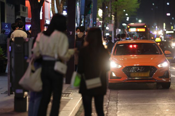 사회적 거리두기가 전면 해제된 지난 18일 서울 강남역 인근에서 자정을 넘긴 시간에도 시민들이 택시를 잡기 위해 서 있다. 연합뉴스