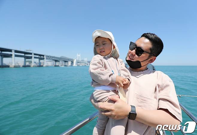 어린이날 100주년인 5일 부산시 남구 용호만유람선터미널에서 출항한 '메가요트 마이다스722호' 에서 부자가 바닷바람을 즐기고 있다. 2022.5.5/뉴스1 © News1 김영훈 기자