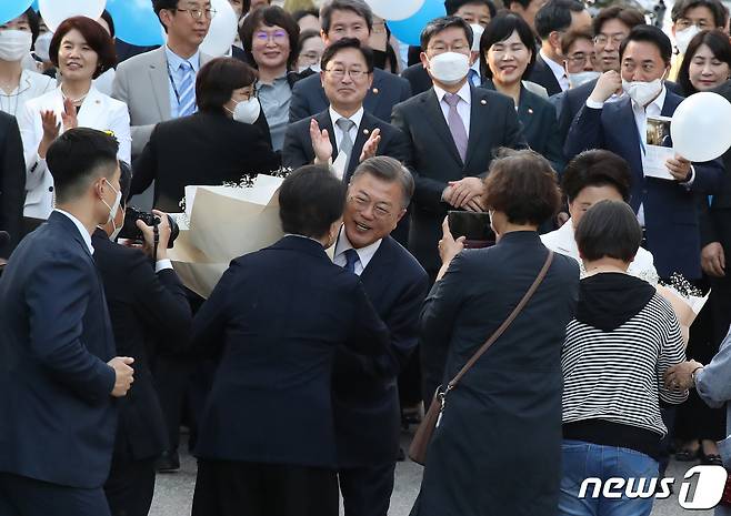 문 대통령 부부가 9일 오후 청와대를 나서며 주민 대표로 나온 시각장애인 모녀에게 꽃다발을 받고 있다. 2022.5.9/뉴스1 © News1 임세영 기자