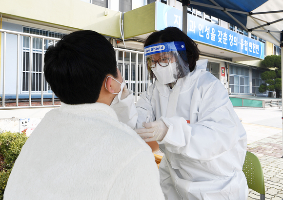 서울 관악구 인헌중학교에서 한 학생이 코로나19 대응 현장 이동형 PCR(유전자증폭) 검사를 받고 있다. [사진=공동취재사진]