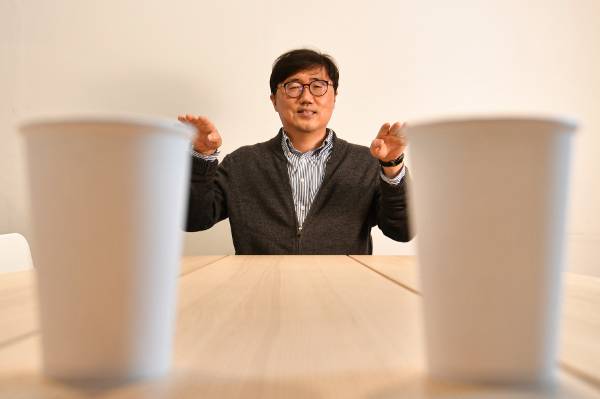 홍수열 자원순환사회경제연구소 소장이 지난 10일 서울 관악구의 한 공유오피스에서 일회용컵 너머로 포즈를 취하고 있다. 홍 소장은 ‘쓰레기 해설가’를 자처하며 20년 넘게 폐기물 처리 문제와 순환경제 정책 등에 목소리를 내온 환경 전문가다. 이한결 기자