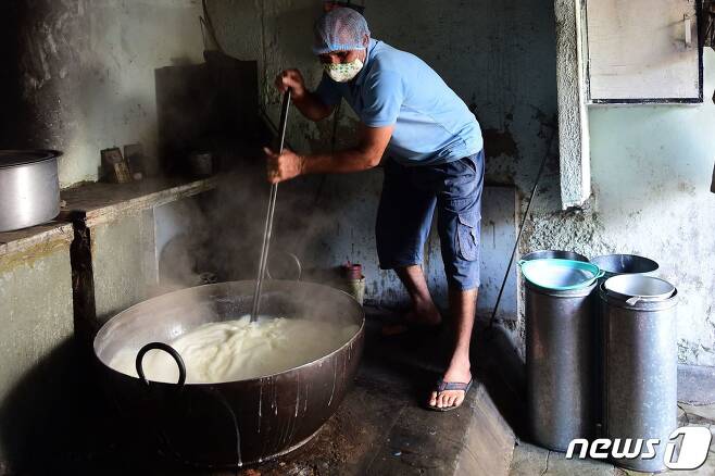 인도 서부 구자라트주 아마다바드에서 한 남성이 우유를 끓이고 있다.  © AFP=뉴스1