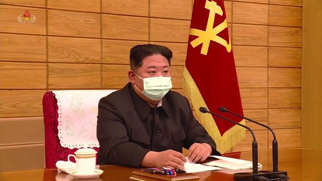 김정은 북한 국무위원장이 14일 노동당 중앙위 정치국이 최대 비상 방역체계 가동을 위해 소집한 협의회에서 마스크를 착용하고 보고를 청취하고 있다.조선중앙TV 화면