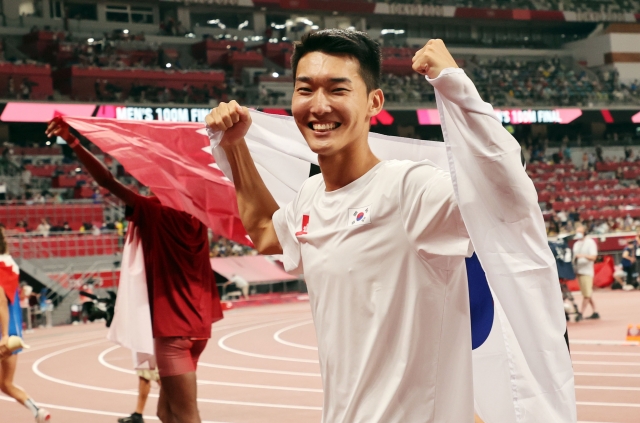 지난해 2020 도쿄올림픽 남자 높이뛰기에서 2m 35 한국신기록을 세우며 4위를 차지한 우상혁이 도쿄 올림픽스타디움에서 경기 종료 후 태극기를 펼치며 기뻐하고 있는 모습. 연합뉴스