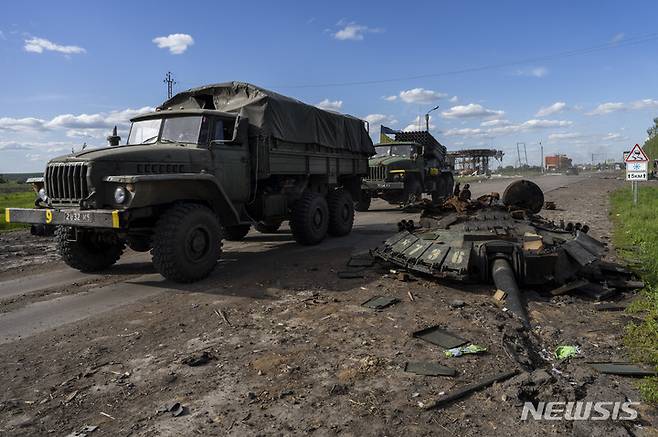 [하르키우=AP/뉴시스] 13일(현지시간) 우크라이나 하루키우 북부에서 우크라이나군 차량이 러시아군 전차 잔해를 지나고 있다. 2022.05.14.