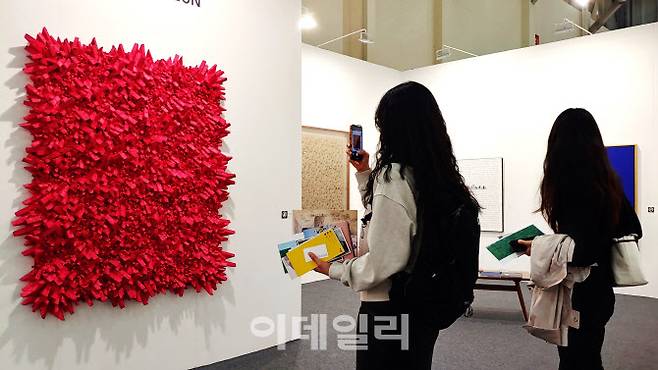 ‘아트부산 2022’의 갤러리조은 전경. 올해 베네치아비엔날레 공식 특별전 초대작가로 나서 주목을 받은 작가 전광영(78)은 붉은색 120호 ‘집합’(Aggregation 15-DE087)은 연신 관람객들의 카메라 세례를 받았다. 작품은 2억 2000만원에 팔렸다(사진=오현주 문화전문기자).