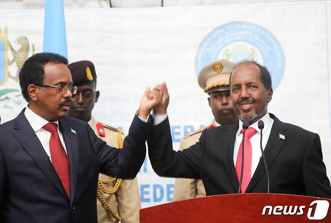 하산 셰이크 모하무드(오른쪽) 소말리아 대통령 당선인이 승리 후 모하메드 압둘라히 모하메드 현 대통령(왼쪽)와 악수하고 있다. 2022.05.16/뉴스1 © 로이터=뉴스1 © News1 김민수 기자