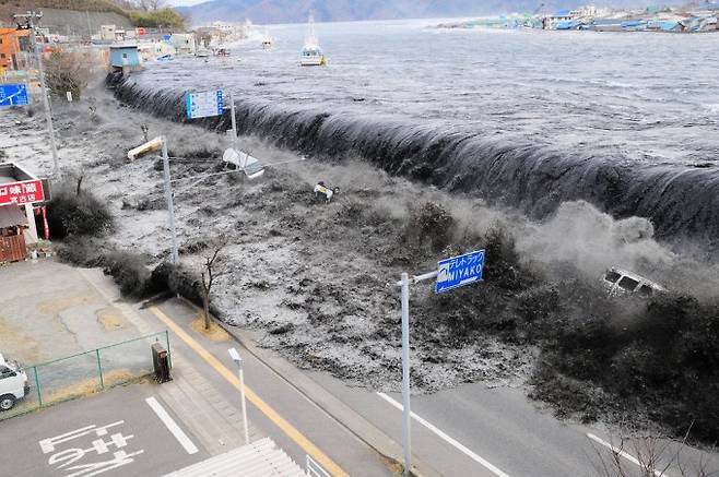 일본 동일본 대지진 당시 쓰나미가 미야코시 헤이가와만의 방파제 위로 무섭게 밀려들고 있는 모습이다. AP/연합뉴스 제공
