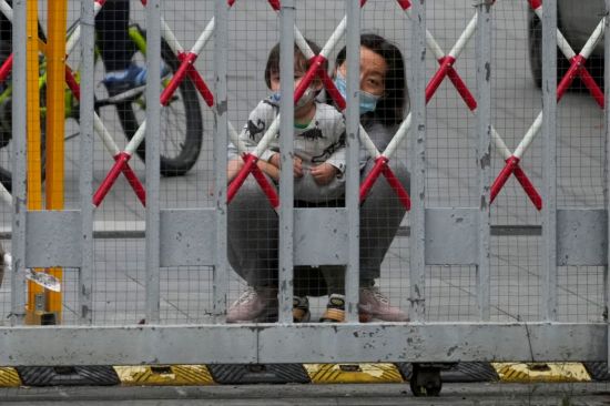 중국 상하이의 코로나19 봉쇄 주거 지역에서 바리케이드 밖을 내다보는 주민. [사진제공=연합뉴스]