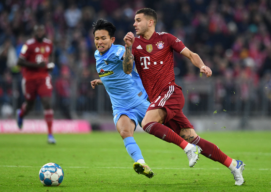 Freiburg's Jeong Woo-yeong, left and Bayern Munich's Lucas Hernandez vie for the ball during a Bundesliga match in Munich on Nov. 6, 2021. [AFP/YONHAP]