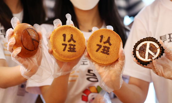 Employees of Daejeon-based bakery Sungsimdang hold up baked goods with images of a voting stamp and messages encouraging people to vote on Tuesday. The event was held ahead of the upcoming local elections on June 1. [YONHAP]