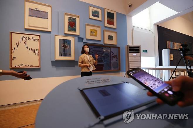 작품 보고 듣고 찍고 (서울=연합뉴스) 강민지 기자 = 17일 오후 서울 종로구 환기미술관에서 열린 '2022 박물관·미술관 주간 기자간담회'에서 참석자가 학예사의 설명을 들으며 QR코드를 통해 작품을 확인하고 있다. 2022.5.17 mjkang@yna.co.kr