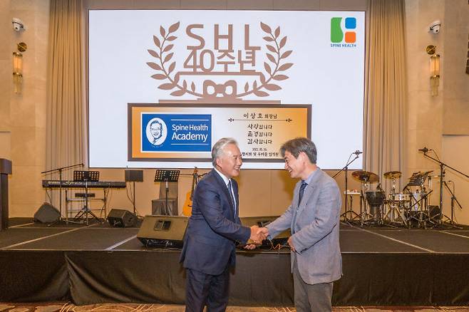 이상호 우리들병원 회장(왼쪽)이 직원 대표로부터 감사패를 전달받고 있다.