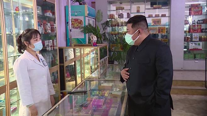 코로나19가 북한을 강타한 가운데 김정은 국무위원장이 지난 15일 마스크 두 장을 겹쳐 쓴 채 평양 시내 약국을 시찰하고 있다. [조선중앙TV 화면]