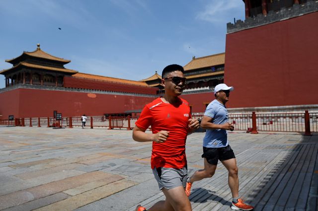 마스크를 착용하지 않은 두 남성이 17일 중국 베이징의 자금성 주위를 달리고 있다. 베이징 당국은 관내 신종 코로나바이러스 감염증(코로나19) 오미크론 변이가 유행하자 자금성을 폐쇄했다. AFP연합뉴스