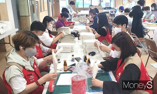 롯데아울렛 광주수완점 샤롯데 봉사단은 18일 광주 점자도서관을 방문해 제8회 전국 동시 지방선거의 점자형 선거공보 1940부 제작에 직접 참여했다/사진=롯데백화점 홍보2팀 제공.